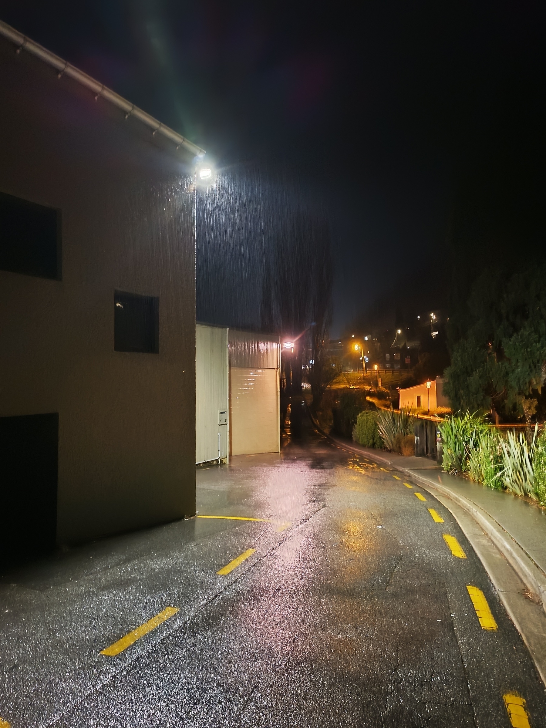 Rain illuminated by lights on corner of buildings